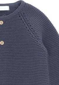 Suéter de punto de color navy con un patrón texturizado, cuello redondeado y cuatro botones de madera. Presenta detalles de punto abierto a lo largo del hombro.