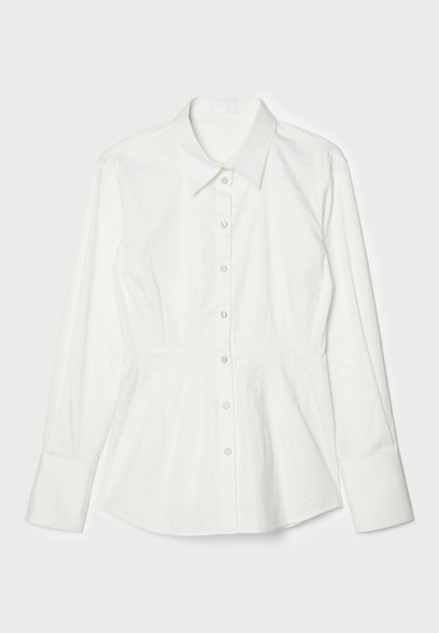 Valkoinen napitettava paita rakenteellisella muotoilulla, pitkät hihat, kaulus ja edessä napitus. Silkkinen puuvillakangas, säädetty istuvuus.