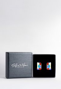 Orecchini geometrici in tonalità oro con un design in smalto che presenta accenti rossi, blu, gialli e bianchi, esposti in una scatola nera.