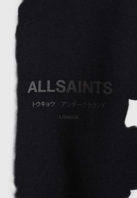 Čierna textília s logom "ALLSAINTS" a ďalším textom v rôznych jazykoch, s hladkým, matným povrchom.