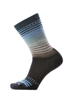 Calza con strisce sfumate blu, grigie e marroni, caratterizzata da piccoli motivi a quadrato sulle aree di caviglia e punta, su sfondo bianco.