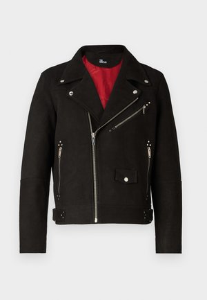 Giacca da moto in suede nero con fodera interna rossa, chiusura a zip diagonale e dettagli in metallo argentato. Presenta tasche con zip e chiusure a pressione.