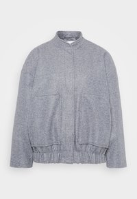 Grå, teksturert jakke med høy krage, elastisk kant og store frontlommer. Har en avslappet passform og minimal sømdetalj.
