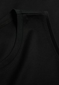 Top nero senza maniche in morbido cotone, con scollatura tonda, cuciture piatte e una texture liscia.