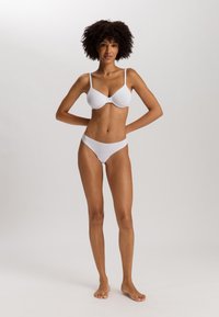 Soutien-gorge blanc sans couture avec bretelles ajustables et culotte blanche assortie, fabriqué à partir d'un matériau lisse et extensible.
