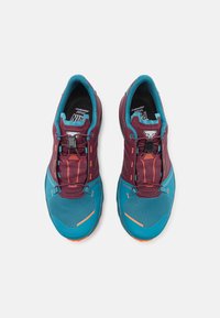 Sportssko med et bordeaux og teal fargevalg, med en pustende mesh-overdel, klare oransje detaljer, og et sikkert snøresystem med toggle.