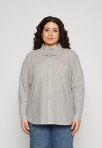Striped blouse with a mock collar, button closure, and dropped shoulder seams. Material has a smooth texture in monochrome colors.