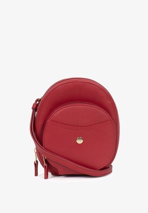 Rote Leder-Crossbody-Tasche mit runder Form, Reißverschluss, Fronttasche und goldenen Hardware-Akzenten. Sanfte Textur und minimalistisches Design.