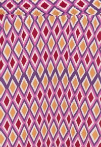 Tissu à motifs présentant un design en diamants dans des teintes de rose, violet, rouge et orange. La texture semble douce avec un léger éclat.