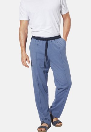 Blue cotton blend pants with an elastic waistband and drawstring, featuring side pockets and a loose fit, paired with brown sandals.