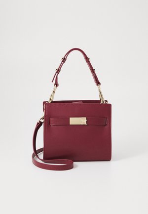 Petit sac à main bordeaux avec poignée supérieure, bandoulière détachable et fermoir rectangulaire doré sur la poche avant.