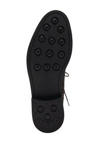 Suela de zapato negra con un patrón texturizado que presenta agarres circulares y un diseño de cara sonriente en el talón. El material parece ser goma.