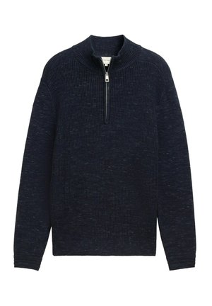 Tmavě modrý pletený svetr s vysokým límcem a polovičním zipem. Texturovaná tkanina se subtilním tečkovaným vzorem, dlouhé rukávy a žebrované manžety.