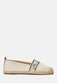 Espadrille de lienzo con parte superior beige, que presenta una banda de logo negra y una suela de cuerda de yute. El diseño incluye un pequeño bucle trasero para facilitar su uso.