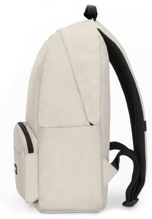 Sac à dos beige clair avec une poche avant zippée, une poche latérale, des bretelles noires rembourrées et une boucle de portage supérieure, vu de côté.