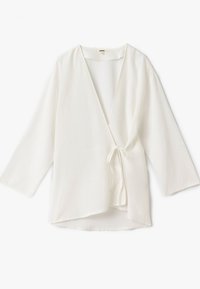 Blusa blanca en estilo envoltura, hecha de un tejido ligero, con escote en V, mangas tres cuartos y un cierre de lazo en la cintura.