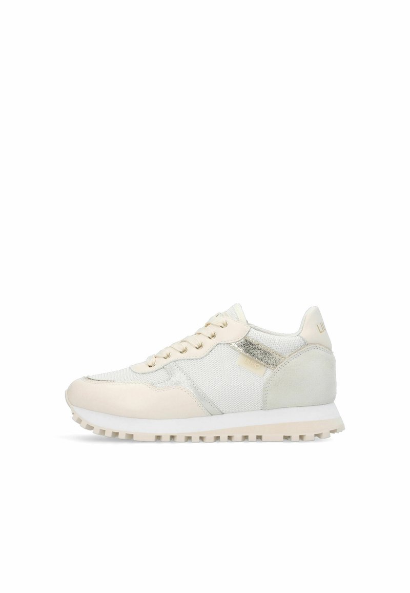 Low-top beige and white sneaker with mesh and leather details, lace-up front, ridged sole, and metallic accent on side panel.