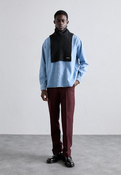 Svart strikket skjerf, lyseblå denim skjorte med knapper, og burgunder bukser. Skinnende svarte sko fullfører antrekket. Enkelt design.