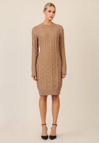 Strickkleid aus Kabelstrick in einem hellbraunen Farbton; mit langen Ärmeln, gerippten Bündchen und Saum, das ein Rautenmuster aufweist.