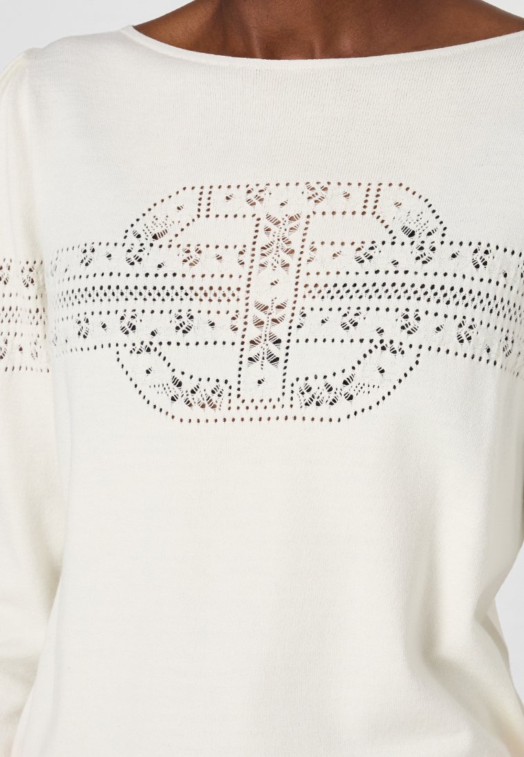 Weißer gestrickter Pullover mit einem Spitzenmuster in der Mitte und entlang der Ärmel, mit einem offenen Bootsausschnitt. Weicher Stoff und leichtes Material.