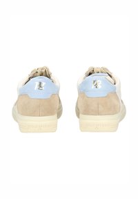 Beżowe zamszowe sneakersy z jasnoniebieskim akcentem na pięcie, kremową podeszwą i khaki sznurowadłami. Na pięcie znajduje się logo.