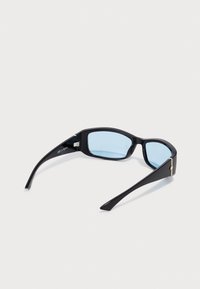 Ochelari negri de soare cu un design elegant, lentile albastre și un accent auriu pe ramă, având temple lungi și o textură netedă din plastic.