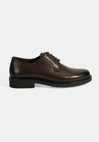 Bruine leren veterschoen met een gladde afwerking, ronde neus en een zwarte rubberen zool. Minimaal aantal naden en klassieke ontwerpelementen.
