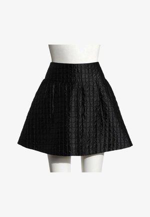 Jupe trapèze matelassée noire à taille haute, présentée sur un mannequin blanc sur un fond uni.