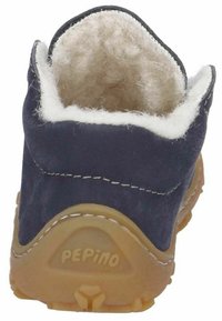 Zapato de cuero azul marino con un suave forro de lana blanca, tacón curvado y suela de goma. Presenta la marca 'PEPino' en la suela.