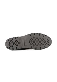 Semelle extérieure en caoutchouc noir avec une surface texturée présentant des motifs géométriques et des trous de drainage pour l'adhérence et l'évacuation de l'eau.