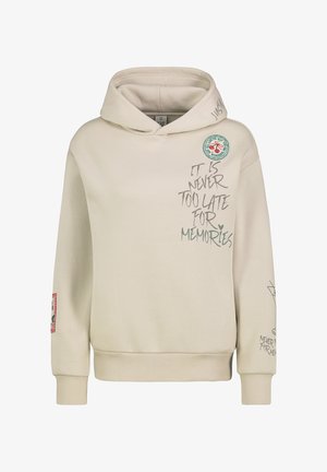 Roomkleurige hoodie met een voorzak, voorzien van tekstgrafieken en een ronde patch op de borst, samen met decoratieve accenten op de mouwen.