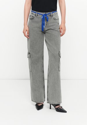 Gray cargo jeans with a loose fit, detailed with side pockets, a blue drawstring waistband, and frayed hem accents.