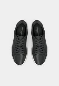 Black leather sneakers with a smooth texture, featuring a round toe, lace-up front, and white rubber sole. Logo printed on the insole.