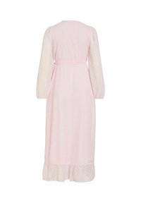 Robe midi rose pâle à manches longues avec de subtils pois, ceinture à nouer à la taille et ourlet volanté, vue de dos sur fond blanc.