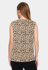 Top senza maniche con stampa animale nei toni beige e marrone; presenta un collo rotondo e un tessuto morbido e testurizzato.