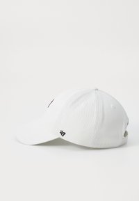 Cappellino da baseball bianco con visiera curva, strap regolabile e accenti neri del logo sulla parte anteriore e laterale. Realizzato in tessuto con una superficie liscia.