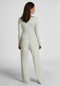 Lichtgroene lange mouw top met een vierkante halslijn, gecombineerd met losse broek, met een gladde, zachte stof en minimale naden.