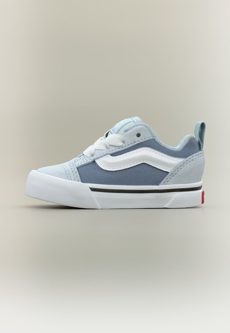 Χαμηλά αθλητικά παπούτσια με ανοιχτό μπλε σουέτ και υφασμάτινα πάνελ, λευκή κυματιστή ρίγα, λευκή υφή σόλας και λευκά κορδόνια.