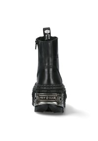 Black leather ankle boot with a zipper, textured platform sole, metal accents, and a branded pull tab at the back. Horizontal stitching visible.
