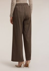 Pantaloni a gamba larga in fantasia check marrone, con vita elasticizzata e tessuto liscio, abbinati a scarpe con tacco beige.