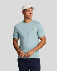T-shirt en coton bleu clair avec un col rond, des manches courtes et un petit accent logo jaune sur la poitrine gauche.