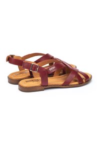 Bruine lederen sandalen met een gestructureerd ontwerp, voorzien van een gesp-sluiting en een platte zool. De voetbed is gewatteerd voor comfort.