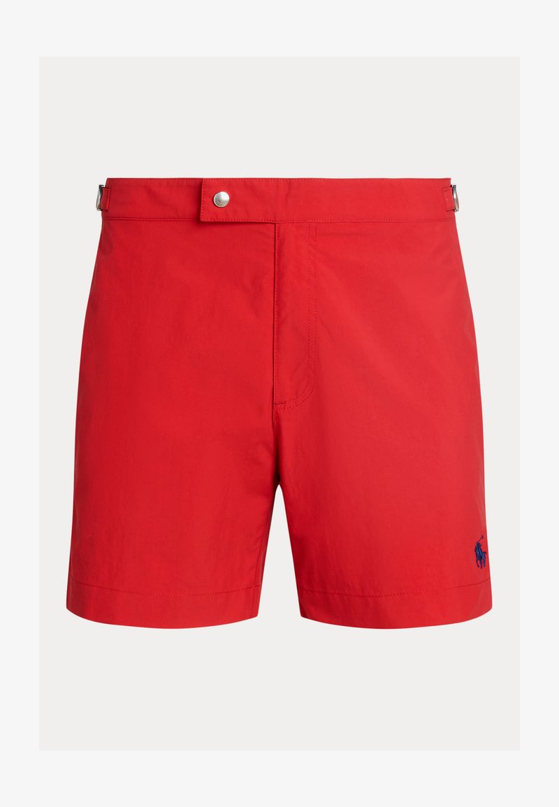 Shorts de bain rouges avec une taille plate, fermeture à bouton et poches latérales. Présente un petit logo bleu en bas. Matériau lisse et léger.