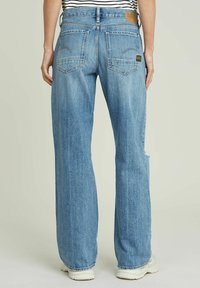 Světle modré džíny z denimu s volnějším střihem, vysokým pasem, dvěma zadními kapsami a detaily s třepením na lemech. Na pásku je značka G-Star.