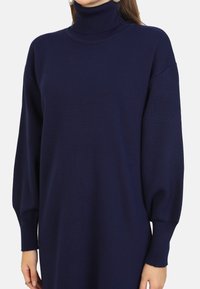 Maglione a collo alto blu navy con vestibilità comoda, polsini a coste e una morbida trama a maglia. Design elegante senza motivi o dettagli visibili.