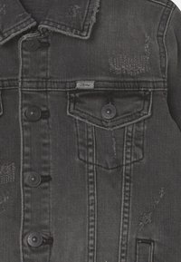 Černá džínová bunda s opotřebovanými detaily, s knoflíkovým zapínáním vpředu, dvěma kapsami na prsou a štítkem označeným "LTB".