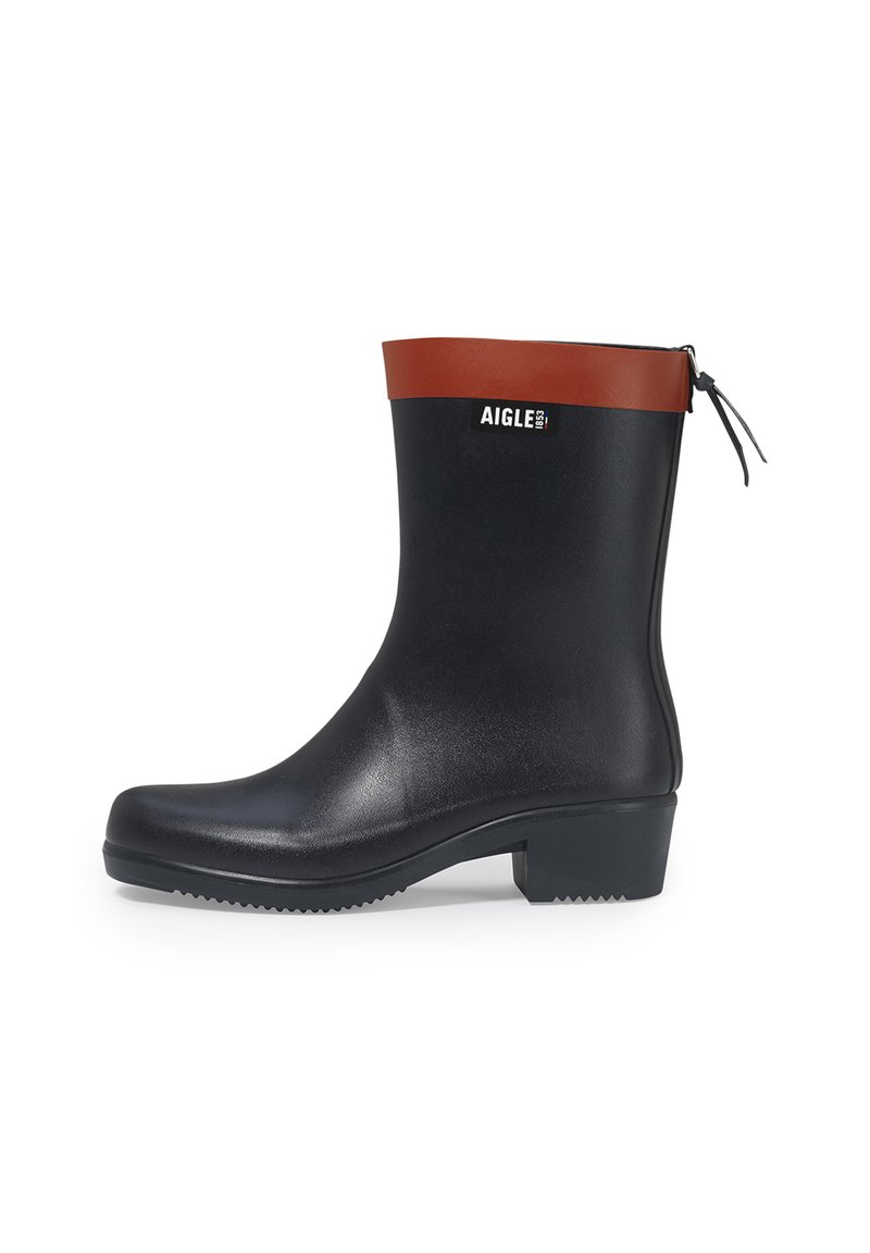 Black waterproof rubber ankle boot with a brown rubber top, logo detail, rounded toe, and thick textured sole. Designed for durability and comfort.
