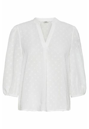 Vit blus med V-ringning, puffärmar och en strukturerad tyg med upphöjda prickar. Löst skuren med rak nederkant.