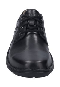 Chaussure noire en cuir à lacets avec une finition lisse, bout rond et semelle robuste. Présente six œillets et une couture contrastante.