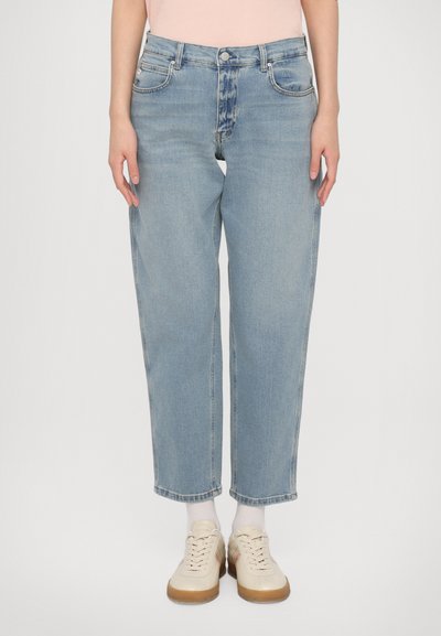 Lichtblauwe denim jeans met een relaxed fit, rechte pijpen, vijf-pocket ontwerp en subtiele vervaging. Gecombineerd met crème-kleurige sneakers.